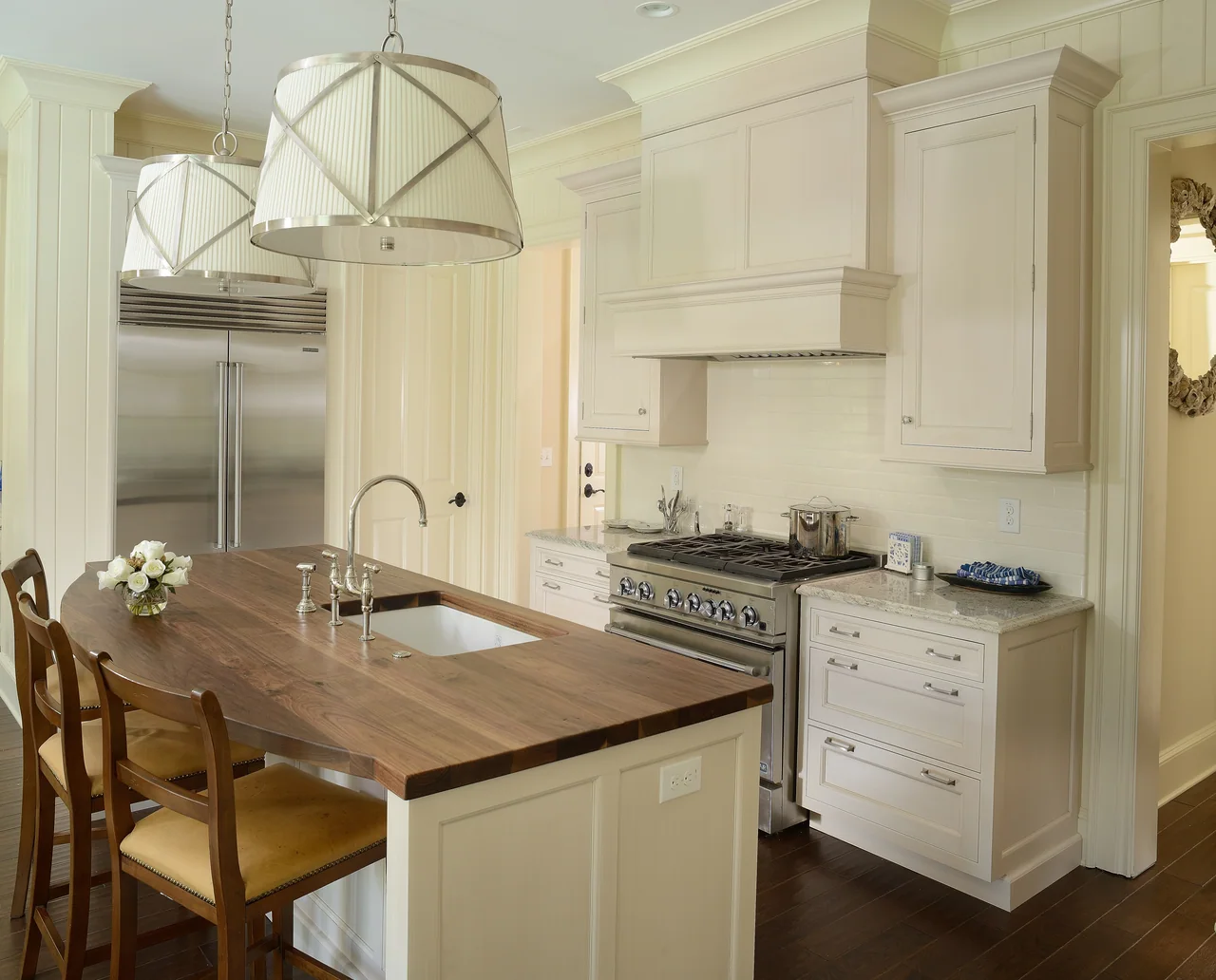 Kitchen with a wood island and sculptural pendant lights