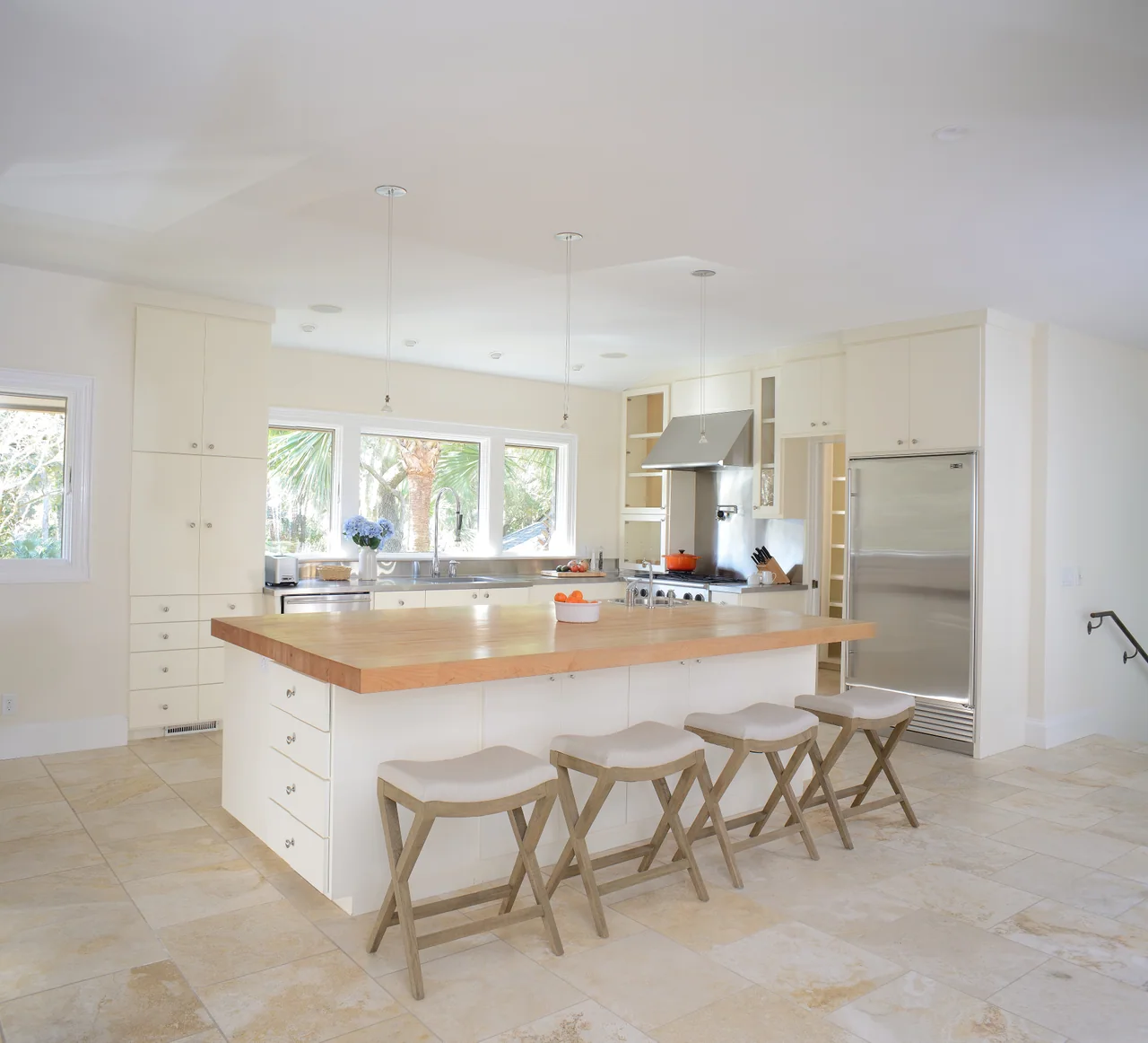 Kitchen with a wood-topped island and white cabinetry